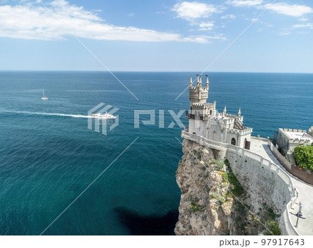 Crimea Swallow's Nest Castle on the rock over the Black Sea. It is a tourist attraction of Crimea. Amazing aerial view of the Crimea coast with the castle above abyss on sunny day. 97917643
