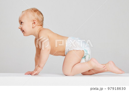 Smiling child. Portrait of little cute toddler boy, baby in diaper crawling isolated over gray studio background. Concept of childhood, motherhood, life, birth. Smiling child. Portrait of little cute toddler boy, baby in diaper crawling isolated over gray studio background. Concept of childhood, motherhood, life, birth. 97918630