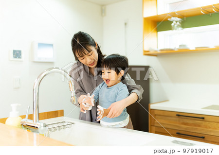 手を洗う2歳の男の子を手伝う母親 97919017