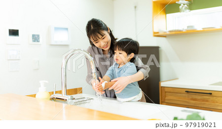 手を洗う2歳の男の子を手伝う母親 97919021