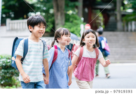 手を繋いで歩道を歩く小学生 97919393