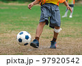 Football soccer children training class. Kindergarten school kids playing football in a field. Group of boys running and kicking soccer on sports grass pitch. Children in sportswear on football match. 97920542