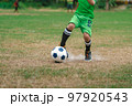 Football soccer children training class. Kindergarten school kids playing football in a field. Group of boys running and kicking soccer on sports grass pitch. Children in sportswear on football match. 97920543