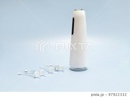 Oral teeth irrigator with nozzle pack, dental water tooth cleaner, white portable rechargeable cordless water dental flosser on blue background. Waterproof home dental care device. Horizontal 97922332