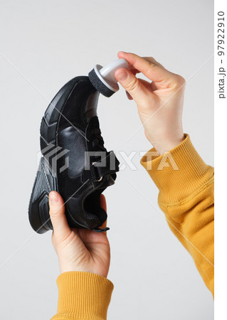 The woman cleanses and applies the cream to the black crumble of the child with a sponge. On a white background, close-up 97922910