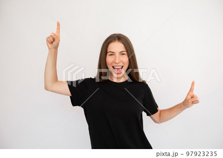 Portrait of excited happy young woman pointing upwards Portrait of excited happy young woman pointing upwards 97923235