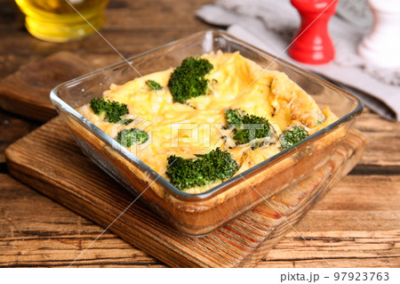 Tasty broccoli casserole in baking dish on wooden table 97923763