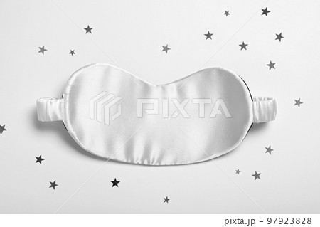 Sleeping mask and glitter on white background, top view. Bedtime accessory 97923828