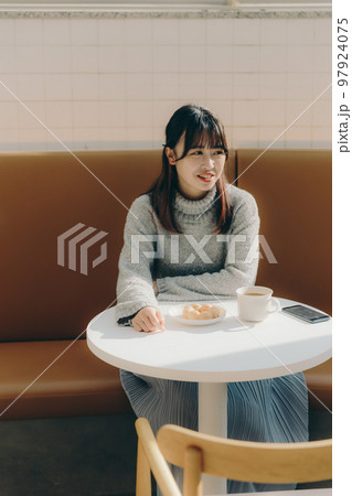 カフェでリラックスしてる女子大生 カフェでリラックスしてる女子大生 97924075