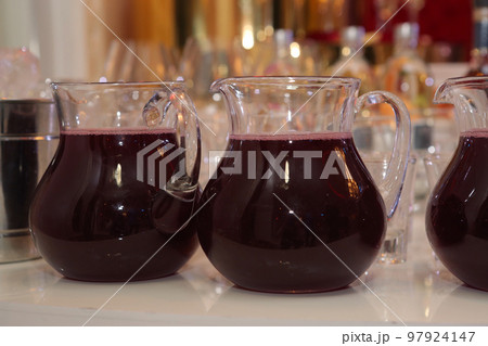 glass jar with morse red fruit drink and wine glasses closeup photo glass jar with morse red fruit drink and wine glasses closeup photo 97924147