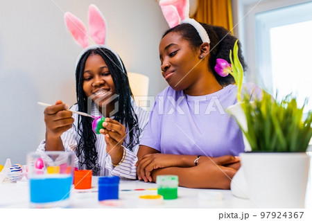 two polyethnic pretty woman having fun and preparing to easter together 97924367