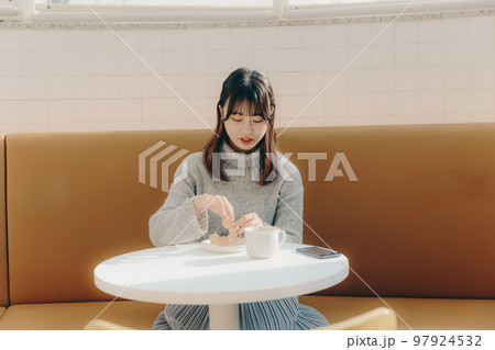 カフェでドーナツを食べる女子大生 カフェでドーナツを食べる女子大生 97924532