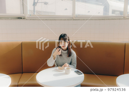 カフェでドーナツを食べる女子大生 カフェでドーナツを食べる女子大生 97924536