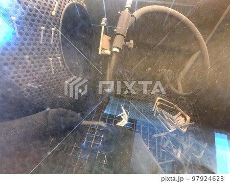 Shot blasting. Shot blasting of model printed on 3D printer from polyamide powder. A worker in sealed rubber gloves cleans the object by shot blasting in a shot blasting chamber. Industrial machine Shot blasting. Shot blasting of model printed on 3D printer from polyamide powder. A worker in sealed rubber gloves cleans the object by shot blasting in a shot blasting chamber. Industrial machine 97924623