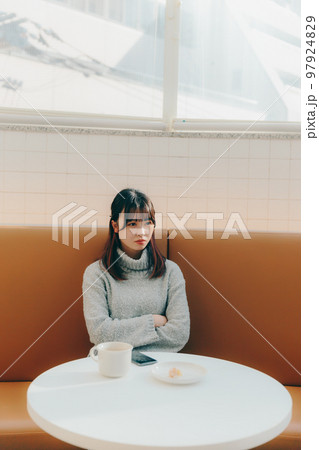 カフェで待ち合わせしている若い女子大生 カフェで待ち合わせしている若い女子大生 97924829