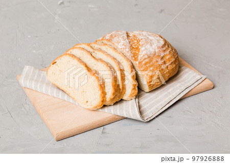 Assortment of freshly sliced baked bread with napkin on rustic table top view. Healthy unleavened bread. French bread slice 97926888