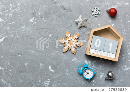 Christmas wood calendar with new year decorations, aganist colored background. Christmas calendar 1 january 97926889