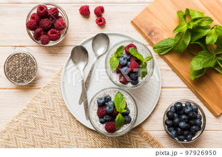 Healthy breakfast or morning with chia seeds vanilla pudding raspberry and blueberry berries on table background, vegetarian food, diet and health concept. Chia pudding with raspberry and blueberry 97926950