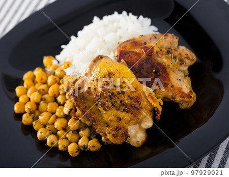 Roasted chicken thighs with chickpeas, rice on black dish Roasted chicken thighs with chickpeas, rice on black dish 97929021