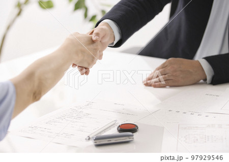不動産契約を結ぶ女性二人の手元 97929546