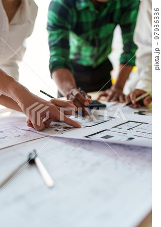 Architect team working with blueprints for architectural plan, engineer sketching a construction project, green energy concept 97936336