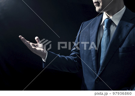手を上げて案内するスーツ姿の男性ビジネスパーソン 97936860