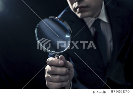 虫メガネで見ている男性ビジネスパーソン 97936870