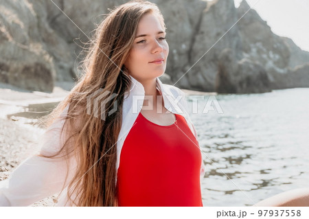 Young woman in red bikini on Beach. Girl lying on pebble beach and enjoying sun. Happy lady with long hair in bathing suit chilling and sunbathing by turquoise sea ocean on hot summer day. Close up Young woman in red bikini on Beach. Girl lying on pebble beach and enjoying sun. Happy lady with long hair in bathing suit chilling and sunbathing by turquoise sea ocean on hot summer day. Close up 97937558