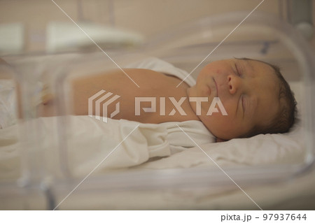Neonatology. A newborn in a special incubator for babies in a hospital. 97937644
