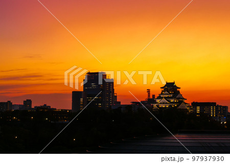 赤く染まった夕暮れ時の大阪城 97937930