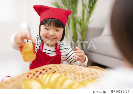 パン屋さんごっこをして遊ぶ女の子 97938217