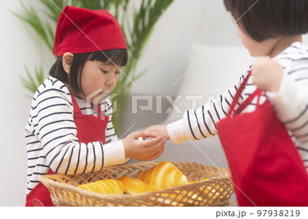 パン屋さんごっこをして遊ぶ女の子 パン屋さんごっこをして遊ぶ女の子 97938219