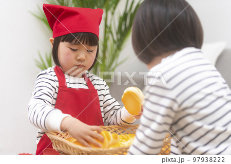 パン屋さんごっこをして遊ぶ女の子 パン屋さんごっこをして遊ぶ女の子 97938222