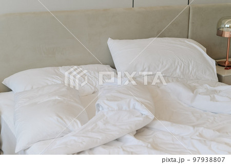 Unmade bedding sheets and pillow. Unmade messy bed after comfortable sleep concept Unmade bedding sheets and pillow. Unmade messy bed after comfortable sleep concept 97938807