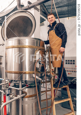 Man is working at craft beer factory. 97939658