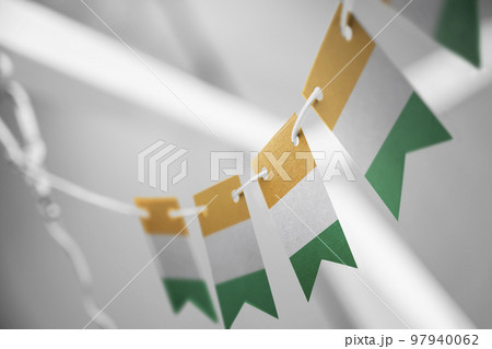 A garland of Cote dIvoire national flags on an abstract blurred background 97940062