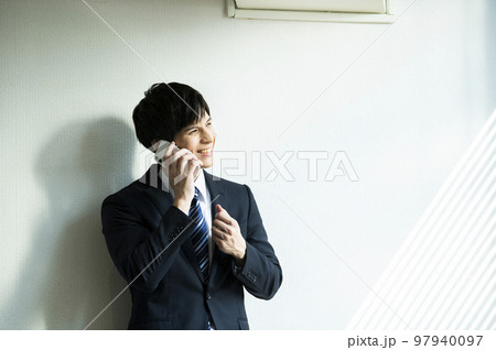 男性　スマホ　電話　オフィス　ビジネスマン　白壁 97940097