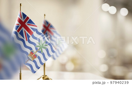 Small flags of the British Indian Ocean Territory on an abstract blurry background 97940239