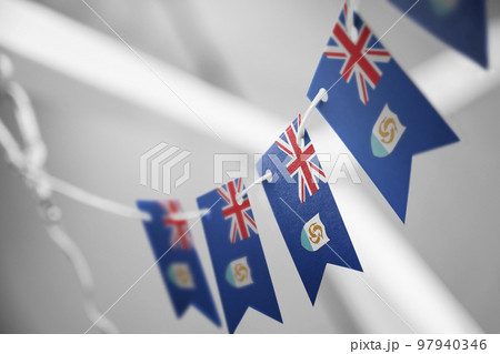 A garland of Anguilla national flags on an abstract blurred background 97940346