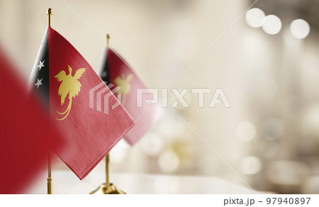Small flags of the Papua New Guinea on an abstract blurry background 97940897