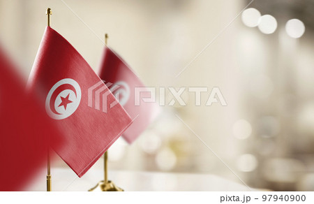 Small flags of the Tunisia on an abstract blurry background 97940900