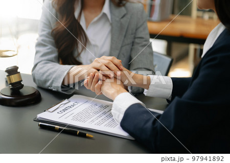 Business people compassionately holding hands and discussing contract papers with laptop and tablet at office Business people compassionately holding hands and discussing contract papers with laptop and tablet at office 97941892