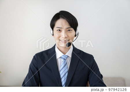 ヘッドセットをつけたスーツ姿の若い男性 97942126