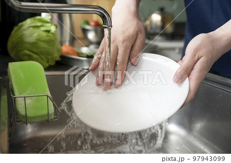 食器を洗う若い男性の手元 97943099