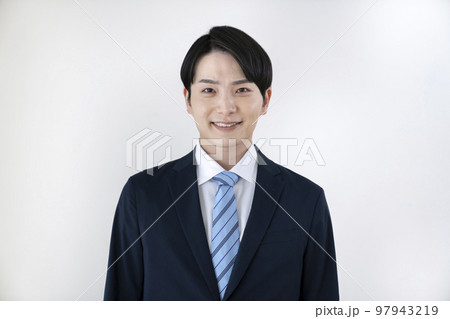 カメラ目線で笑顔のスーツを着た20代の男性　ポートレート 97943219