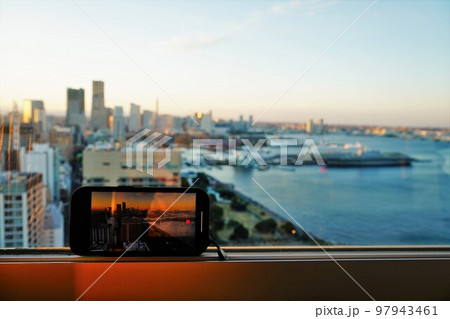 夕焼けの街並みをスマホで撮影 97943461