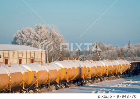 Snow covered tank-wagons with a crude oil standing on the railway 97943770