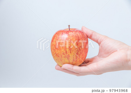 赤いりんごを持つ女性の手 97943968