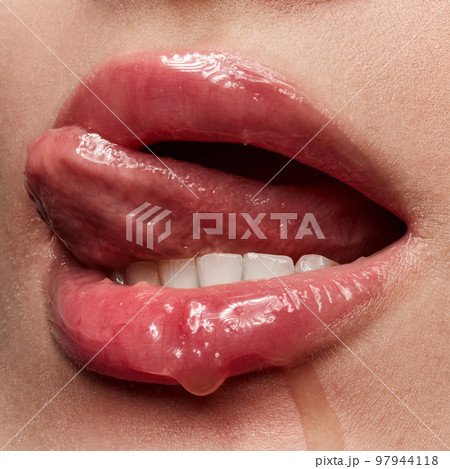 Closeup sexy female lips with nude color lipstick. Sensual women's open mouth with sticking out tongue. Beauty, fashion, style concept 97944118