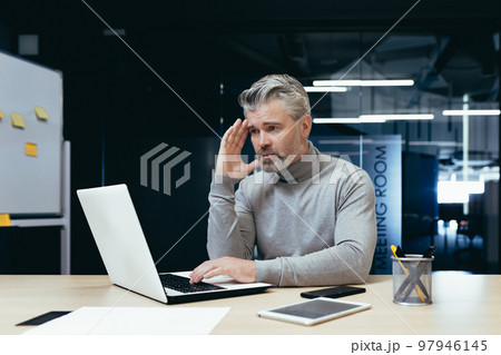 Senior thinking businessman working inside office with laptops, man thinking about important financial decision. Senior thinking businessman working inside office with laptops, man thinking about important financial decision. 97946145